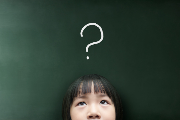 young girl using cognitive flexibility in front of chalkboard with a questions mark over her head